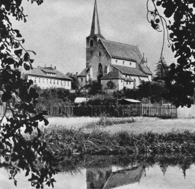 Westansicht der Stadtpfarrkirche St. Johannes Baptista. Chor gotisch von 1389. Fertigstellung 1461, mit Anbauten: Marienkapelle, Sakristei, Oelberg. Emporenaufgang Ende des 17. Jahrhunderts. Inneres neugotisch erneuert 1891. Völlige Restaurierung des Inneren 1950.