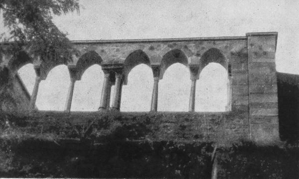 Aura. Kreuzgang. An der südwestlichen Friedhofsmauer. Sechs frühgotische Spitzbogenfenster, zusammengestellt mit einer Säulengruppe aus Kreuzgangresten. 1874.